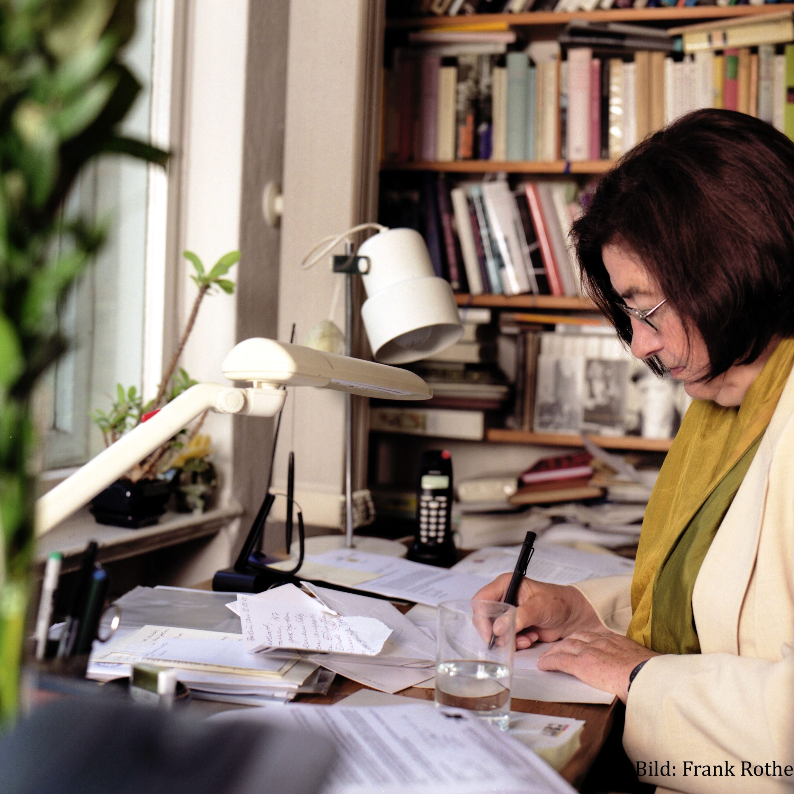 Das Bild zeigt Christa Wolf am Schreibtisch sitzend